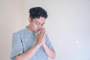 Moslem Asian man prayer gesture when Ramadan celebration. The photo is suitable to use for Ramadhan poster and Muslim content media.