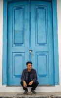 Man sitting in front of the gate smiling relax. The photo is suitable to use for travel destination background and content media.