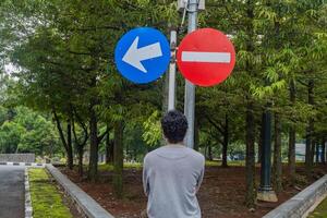 Man look to the sign direction traffic. The photo is suitable to use for adventure and travel destination content media.