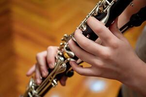 cerca arriba de para niños manos jugando el clarinete en un música estudio foto