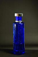 Transparent Dark Blue Bottle Perfume isolated black background for mock up design photo