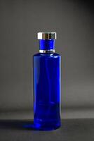 Transparent Dark Blue Bottle Perfume isolated black background for mock up design photo