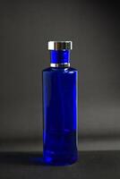 Transparent Dark Blue Bottle Perfume isolated black background for mock up design photo
