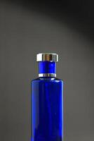 Transparent Dark Blue Bottle Perfume isolated black background for mock up design photo