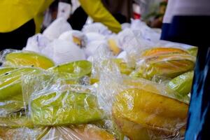 Starfruits in transparent plastic displayed in market fruit photo