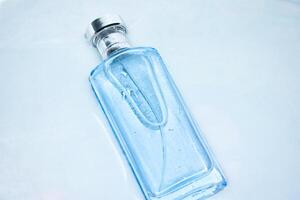 Blue Bottle Perfume in water splash background with Top angle View. photo