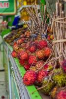 Groups of rambutan fruits displayed in supermarket box photo
