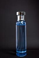 Transparent Blue Bottle Perfume isolated black background for mock up design photo