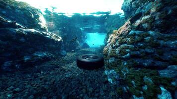 An underwater view of a tire in a rocky area video