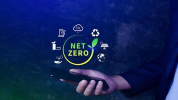 Net Zero and Carbon Neutral Concepts, Net zero greenhouse gas emissions target, Climate neutral long strategy, Businessman holding NetZero icon with smartphone. photo