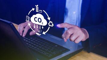 Hand holding CO2 reducing virtual icon for decrease carbon dioxide emission, carbon footprint and carbon credit to limit global warming from Bio climate change concept. photo