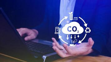 Hand holding CO2 reducing virtual icon for decrease carbon dioxide emission, carbon footprint and carbon credit to limit global warming from Bio climate change concept. photo