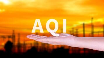 AQI, Abbreviation of air quality index, hand holding AQI on nature background, environment concept. photo