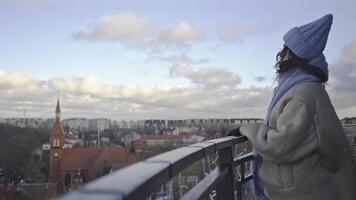 meisje in blauw hoed en jasje staand Aan balkon video