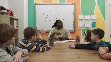 africain américain prof enseigne une groupe de les enfants mathématiques dans le Salle de classe. école pour enfants, enseignement adolescents, Gain connaissance, apprendre le langue. video