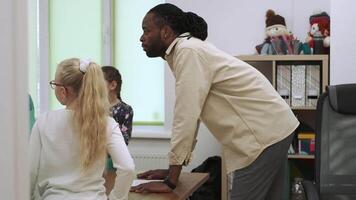 afrikanisch amerikanisch Lehrer und Gruppe von Kinder während ein Lektion im das Klassenzimmer.Schule zum Kinder, Lehren Jugendliche, dazugewinnen Wissen, lernen das Sprache. video