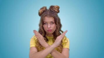 attractive young girl in a yellow T-shirt shows a gesture of prohibition. green screen video