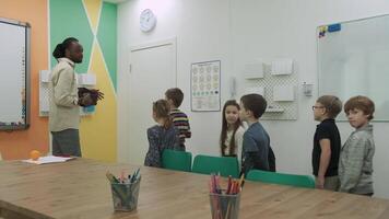 ein afrikanisch amerikanisch Lehrer unterrichtet ein Gruppe von Kinder 10-12 Jahre alt, studieren Tiere und Früchte.Schule zum Kinder, Lehren Jugendliche, dazugewinnen Wissen, lernen das Sprache. video