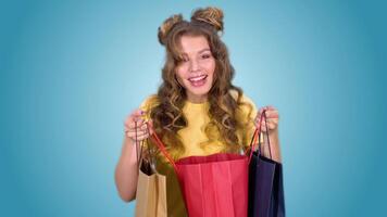 A beautiful young girl in a yellow vest with styling after shopping opens the package and enjoys shopping. green screen video