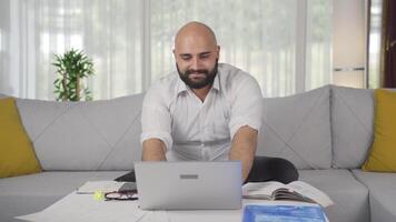 Home office worker man rejoices at what he sees on the laptop. video