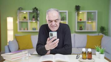 le vieux homme qui est parlant sur le téléphone obtient émotionnel. video