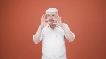 The man making the small sign with his hand. video