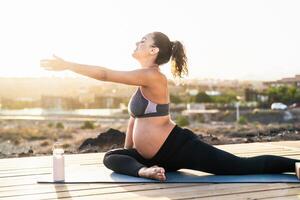 joven embarazada mujer haciendo yoga sesión siguiente el mar - meditación y maternidad concepto foto