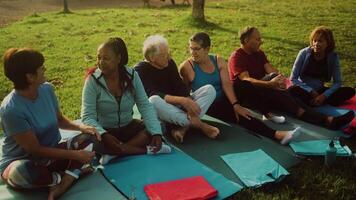 groep van senior persoon hebben pret zittend Aan mat na training werkzaamheid. video