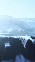 rangée de falaises sombres pointues se détachant de la neige video