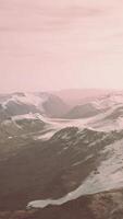 grande mancha de neve deixada no campo de rocha vulcânica de uma montanha no verão video