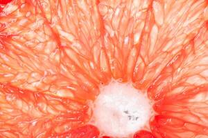 The texture of a red grapefruit in the section with the center, a macrophotography of fruits photo