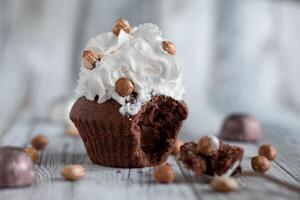 Delicious chocolate brownie muffins with nuts and whipped cream photo
