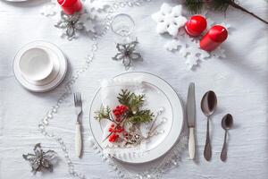 festivo mesa ajuste con un blanco Manteles y platos. decoración para el nuevo año y Navidad foto