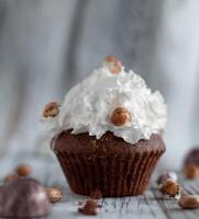 Delicious chocolate brownie muffins with nuts and whipped cream photo