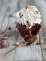 Delicious chocolate brownie muffins with nuts and whipped cream photo