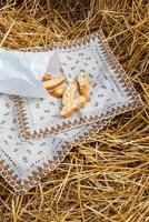 Almond cookies crackers with pieces of nuts lie on a napkin against the background of straw. A snack in nature photo