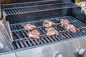 Raw chicken on the grill photo
