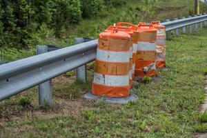 Construction barrels alongside a guardrail photo