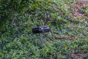 Abandoned barbecue grill in the woods photo