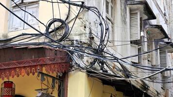 A tangled mess of cables on the outside of a house photo