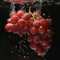 Red grapes falling in water with splash on black background. photo