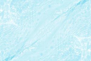 Bluewater waves on the surface ripples blurred. Defocus blurred transparent blue colored clear calm water surface texture with splash and bubbles. Water waves with shining pattern texture background. photo