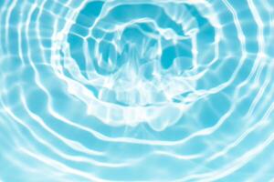 Bluewater waves on the surface ripples blurred. Defocus blurred transparent blue colored clear calm water surface texture with splash and bubbles. Water waves with shining pattern texture background. photo