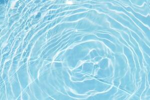 Blue sea waves on the surface ripples blurred. Defocus blurred transparent blue colored clear calm water surface texture with splash and bubbles. Water waves with shining pattern texture background. photo