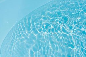 Bluewater waves on the surface ripples blurred. Defocus blurred transparent blue colored clear calm water surface texture with splash and bubbles. Water waves with shining pattern texture background. photo
