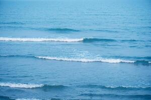 agua Azul olas en el superficie ondas borroso. desenfocar borroso transparente azul de colores claro calma agua superficie textura con chapoteo y burbujas agua olas con brillante modelo textura antecedentes. foto