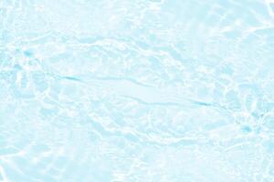 Bluewater waves on the surface ripples blurred. Defocus blurred transparent blue colored clear calm water surface texture with splash and bubbles. Water waves with shining pattern texture background. photo