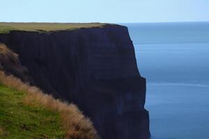 Seaside Majesty Breathtaking Coastal Cliffs Meet Stunning Blue Sea, A Spectacle of Nature's Grandeur photo