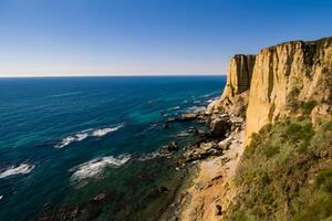 Seaside Majesty Breathtaking Coastal Cliffs Meet Stunning Blue Sea, A Spectacle of Nature's Grandeur photo