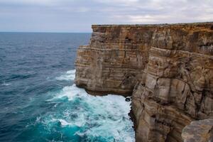 Seaside Majesty Breathtaking Coastal Cliffs Meet Stunning Blue Sea, A Spectacle of Nature's Grandeur photo